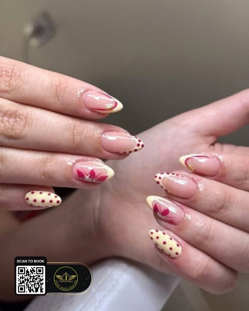 Butter-yellow French tips with burgundy flowers and polka dots by Jimmy Nails & Spa.