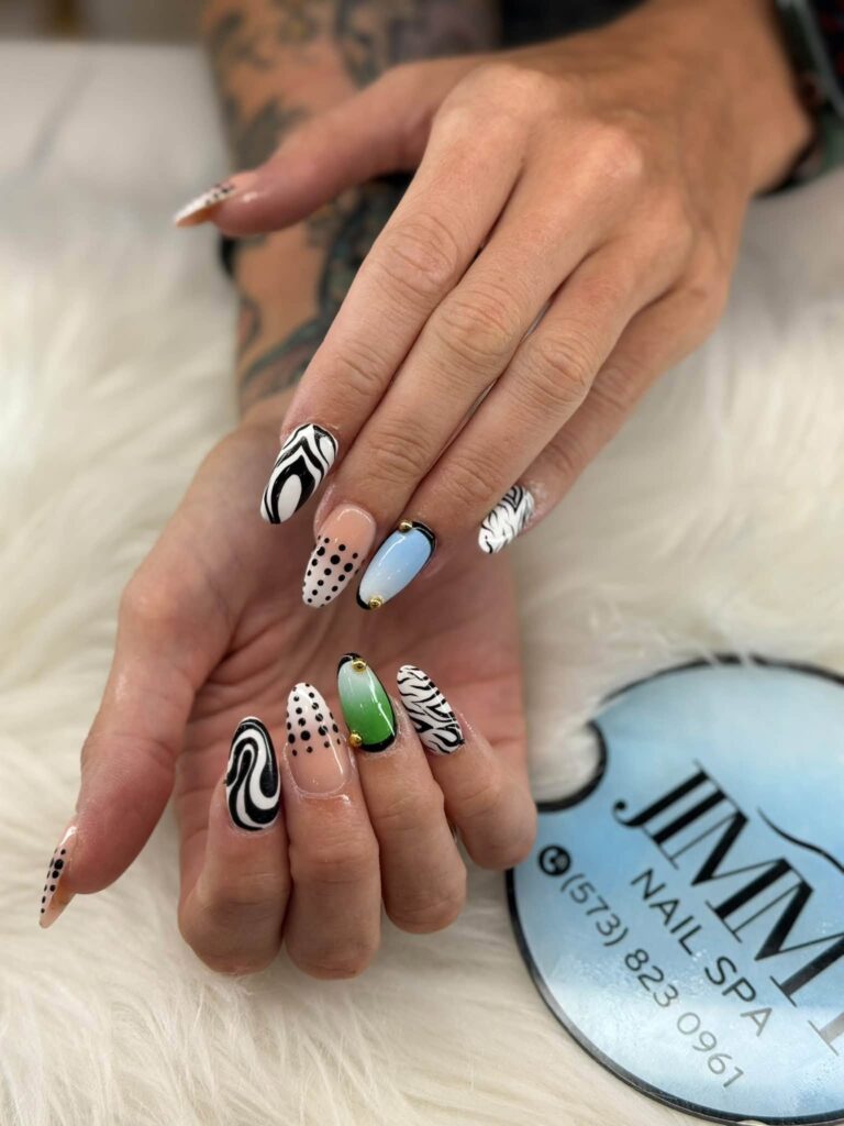 Black-and-white patterns with blue and green accent nails at Jimmy Nails & Spa.