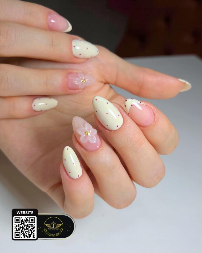 Cream polka-dot nails with pink floral accents by Jimmy Nails & Spa.