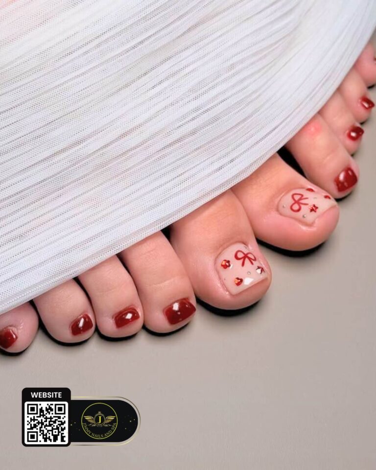 Burgundy pedicure with pink bow accent nails by Jimmy Nails & Spa.