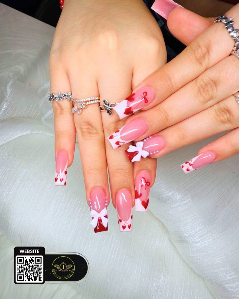 Pink and red nail art with heart details and white bows by Jimmy Nails & Spa.