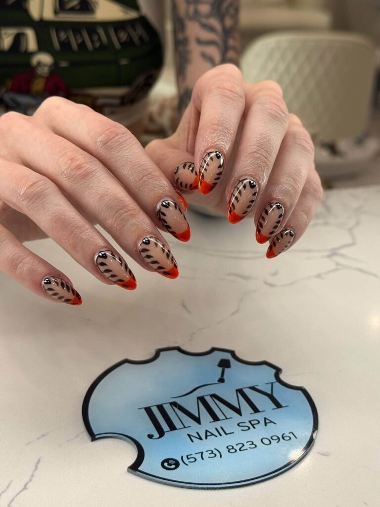 Leopard-print nails with orange French tips at Jimmy Nails & Spa.